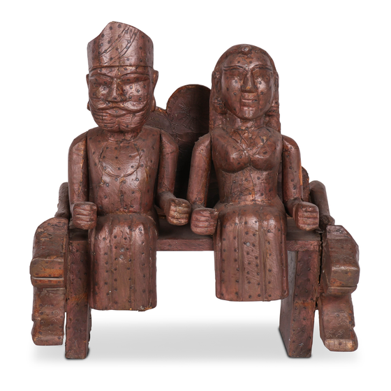 Statue wood man and wife on bench sideview
